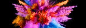 An explosion of vivid different colour powders against a black background.